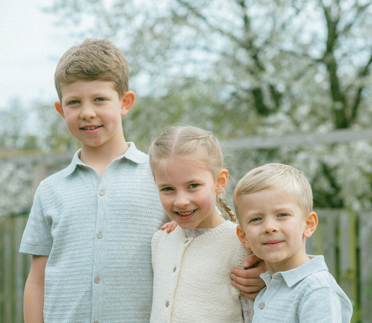 Three kids together in a beautiful photo taken in the garden